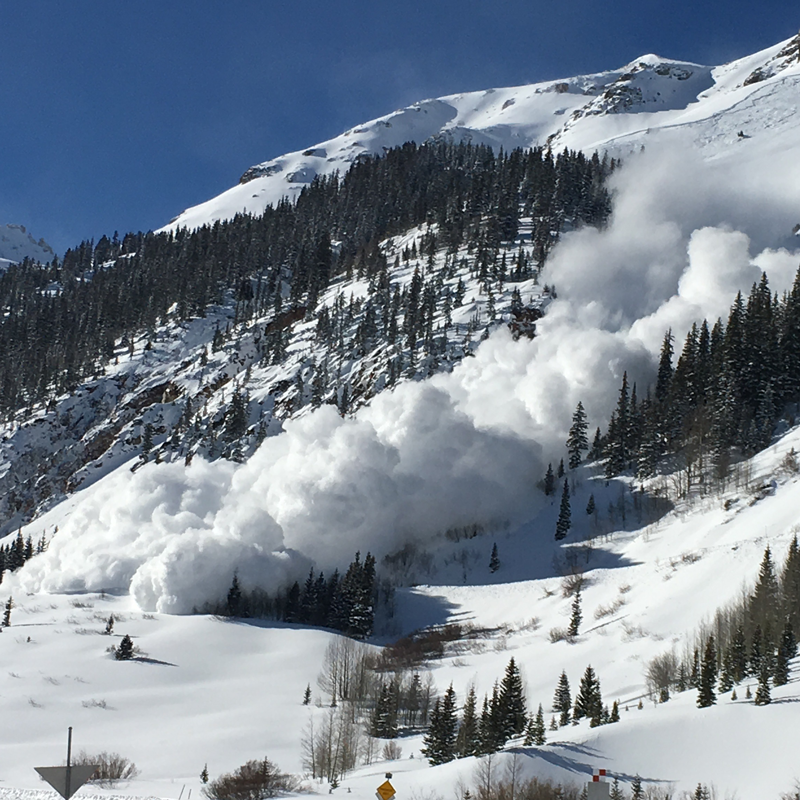 Crews in a tractor performing an avalanche mitigation
