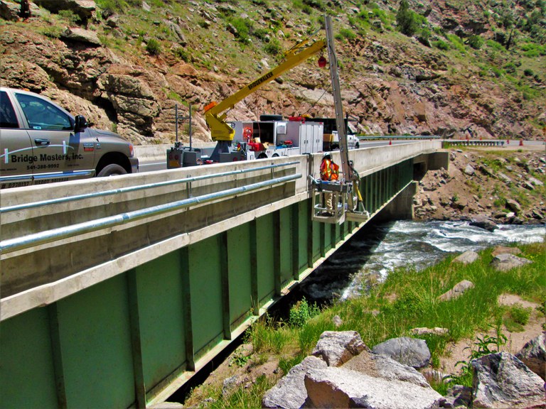 a crew installing bridge mounted conduit